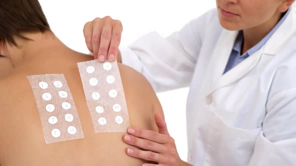 Woman therapist putting bands on the back of her patient