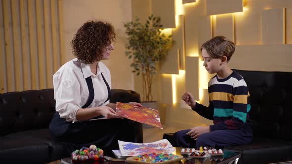 Boy and Child Psychologist Discussing His Drawing