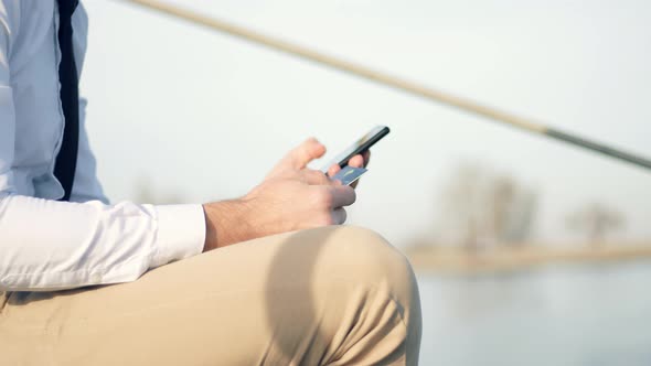 Man Using Mobile Phone And Credit Card For Shopping Online Outdoors. Online Banking With Smartphone.