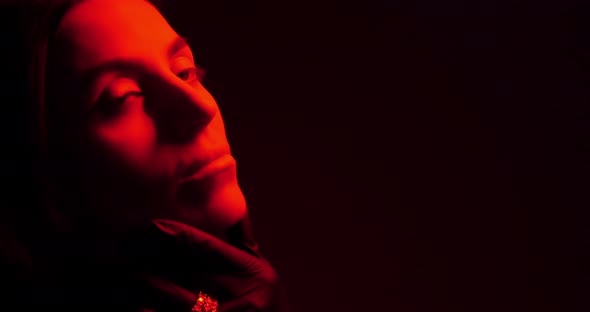 Female Face In The Dark Illuminated By Red Light