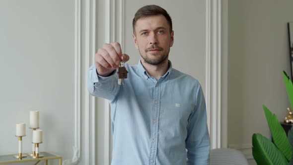 Man Shows the Keys to His New Apartment in the Living Room