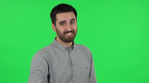 Portrait of Brunette Guy Is Waving Hand and Showing Gesture Come Here. Green Screen