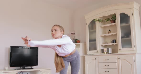 Fitness woman working out on core muscles at home. Yoga class in the midday. 