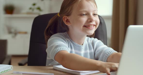 Cute Little Preschool Girl Daughter with Excited Face Expressions Playing Online Games on Laptop