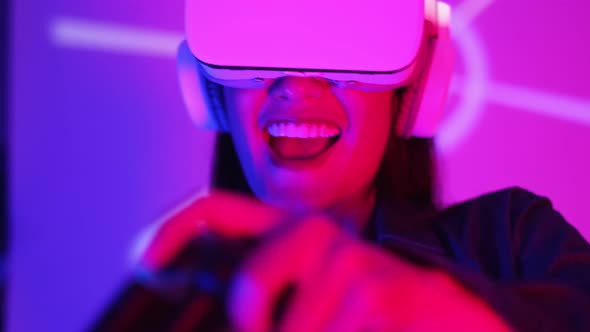 Young asian woman is using virtual reality headset. Neon light studio portrait.