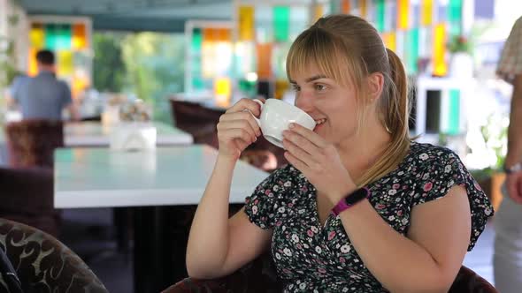 Happy Woman Drink Tea in a Cafe and Relaxing