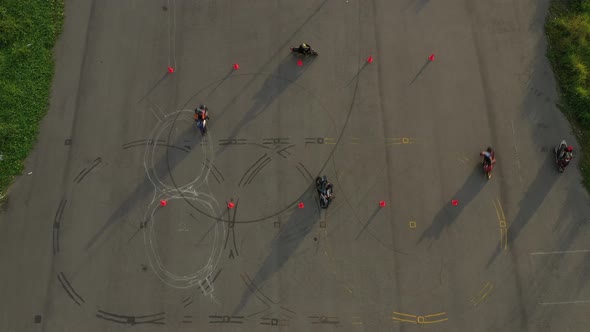 top down wide aerial view of a group of riders practicing on an advanced motorcycle training slalom