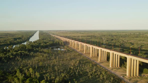 Dolly in of Zarate Brazo Largo road and railway complex cable-stayed bridge between green fields and