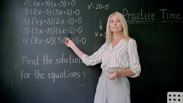 Webcam View of Teacher Explaining Math Formulas on Online Lesson at Chalkboard