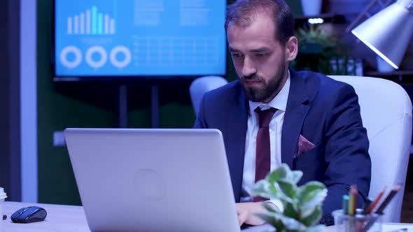 Excited Businessman Dances at His Desk Late in the Night