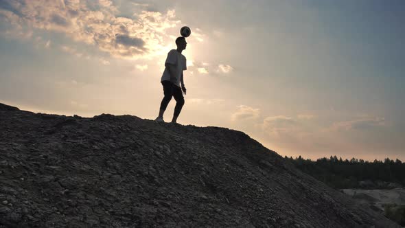 Man on Top of the Mountain Shows Tricks with the Ball.