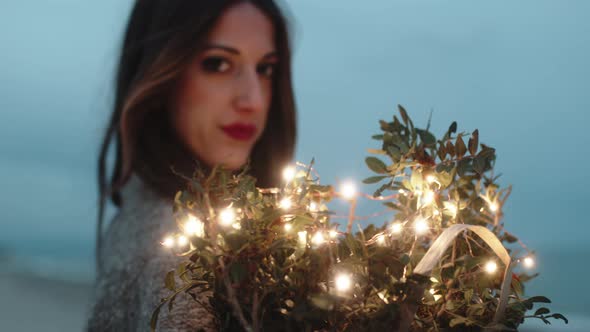 Sweet Girl Squeezes to Herself Bouquet of Flowers with Lights