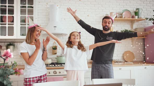 Happy Family with a Daughter Celebrating Birthday in Kitchen Using Laptop for a Video Call During