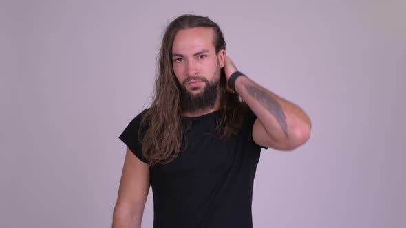 Stressed Young Bearded Hipster Man with Long Hair Giving Thumbs Down