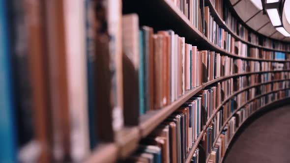 Stedicam. Camera Moves Forward Along Shelves Filled with Paper Books