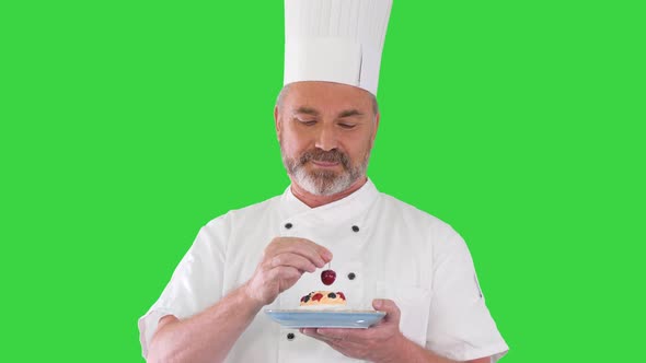 Chef Putting Cherry on Top of the Cake Before Serving It Icing on the Cake on a Green Screen, Chroma