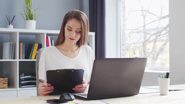 Young Woman Works at Home Office Using Computer.