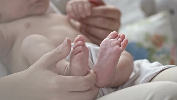 Mother Gently Touching Baby Feet