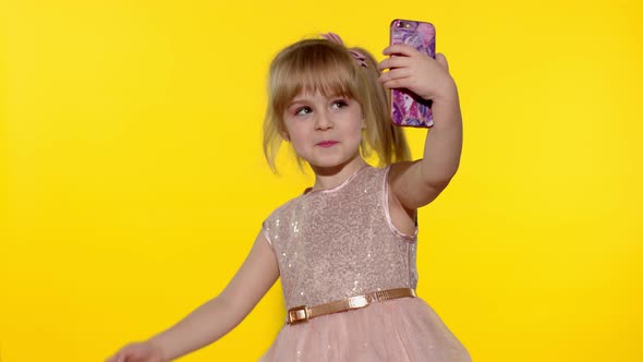 Child Girl Using Smartphone. Portrait of Blonde Kid Emotionally Makes Selfie on Mobile Phone