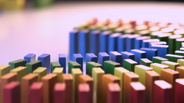 Line up of Dominoes in Rainbow Falling Colors with LGBT Colors of a Hand