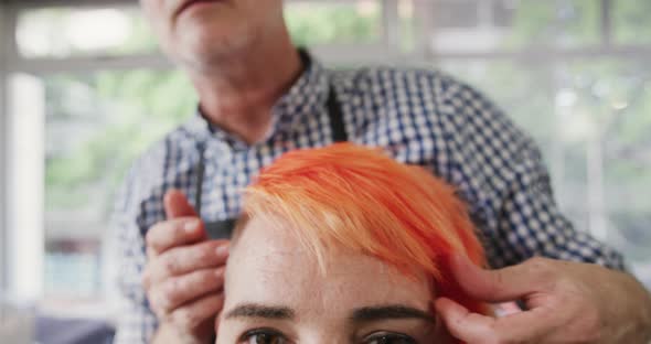 Front view hairdresser arranging woman hair