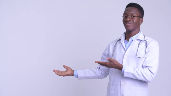 Young Happy African Man Doctor Showing Something