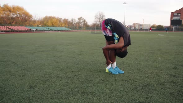 Young Black Girl Working Out at the City Stadium and Doing Static Stretching Exercises with Her Head