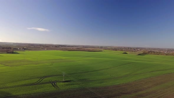 Drone shot of rolling green fields and blue skies