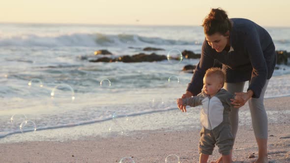 Mother and baby boy playing in the beach