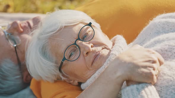 Romance at Old Age. Retired Couple Enjoying Autumn Picnick. Lying on the Blacnket and Looking at