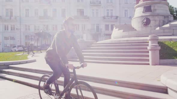 Cyclist Man Riding Fixed Gear Sport Bike in Sunny Day on a City