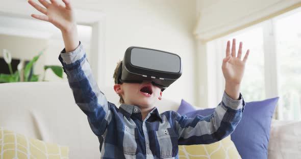 Caucasian boy waving hands and talking during playing with vr headset