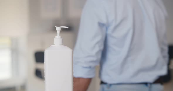 Cropped Short of Diverse Employees Working in Modern Office Using Hand Sanitizer to Disinfect Hands