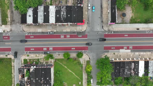 Violence in America theme. Top down aerial tracking of inner city rowhomes on summer day.