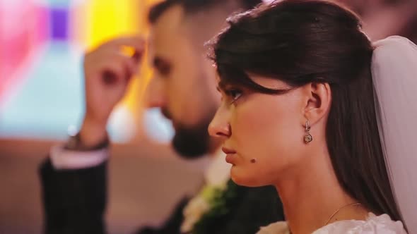 Close-up Profile View of Beautiful Bride Face in a Luxurious White Dress and Her Fiance in a Stylish