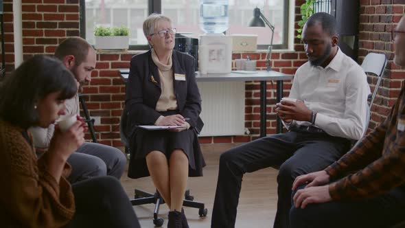 Psychologist Having Conversation with People in Circle at Aa Group Therapy Session