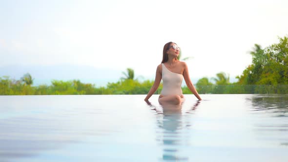 Young asian woman enjoy around outdoor swimming pool for leisure