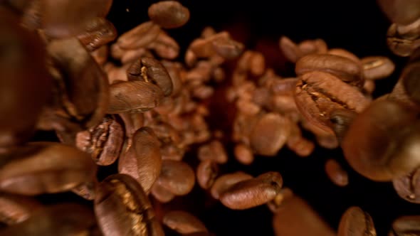 Super Slow Motion Detail Shot of Coffee Beans Falling Down on Black Background at 1000Fps