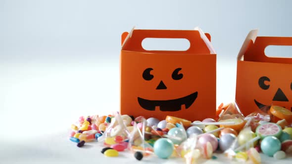 Halloween box with various candies on white background 4k