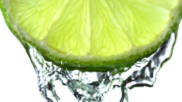 Super Slow Motion Macro Shot of Flowing Water From Lime Slice on White Background at 1000Fps