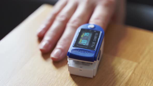 Woman at Home with Pulse Oximeter on Finger