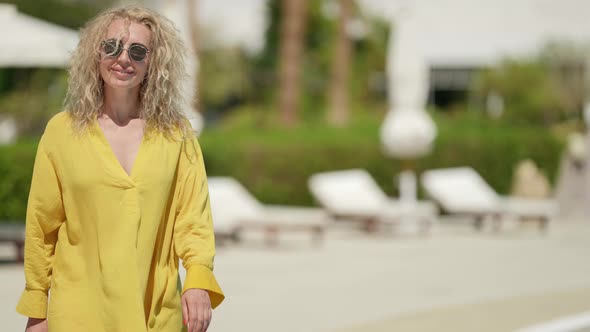 Charming Blonde Woman with Sunglasses is Resting in Hotel in Summer Vacation