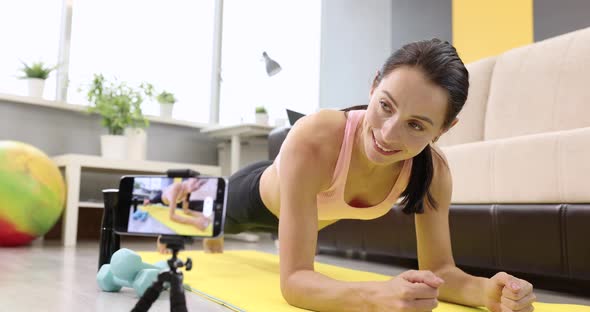 Young Woman Doing Physical Exercises Standing on Board on Mat Taking Pictures on Camera Slow Motion