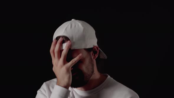 Trendy 20s Man giving extreme facepalm, shaking head , close, black background