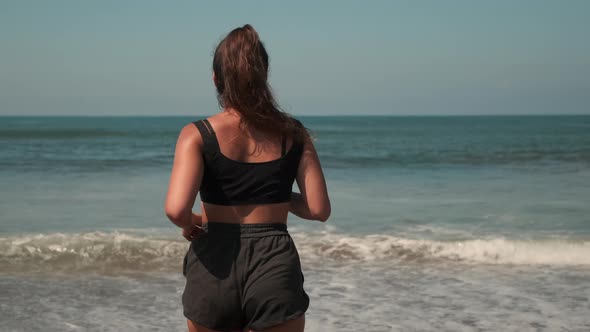 Attractive Female Jogging Against Ocean