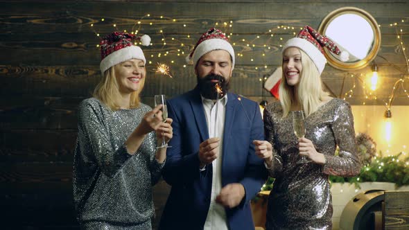 Friends Celebrating Christmass or New Year. Group of People Drinking Champagne with Sparkling Bengal