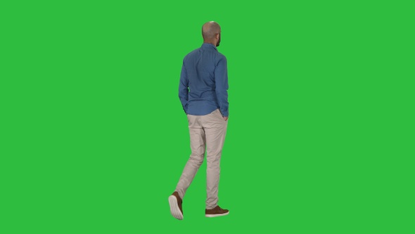 Casual young man walking on a Green Screen, Chroma Key.