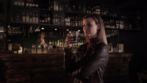 Fashionable Cafe, a Beautiful Girl in a Great Bar with a Tasty Drink in Her Hands Looks at Bartender