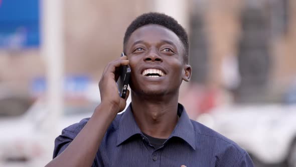 Good news,success. Happy smiling young black man at phone rejoicing- slow motion