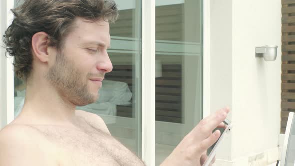 Man using smartphone while sunbathing